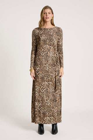 Woman wearing a long-sleeved leopard print maxi dress and black ankle boots.