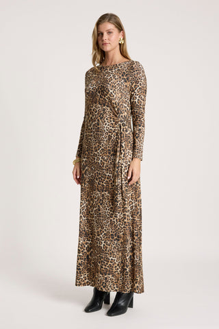 Woman wearing a long-sleeve leopard print maxi dress and black ankle boots.