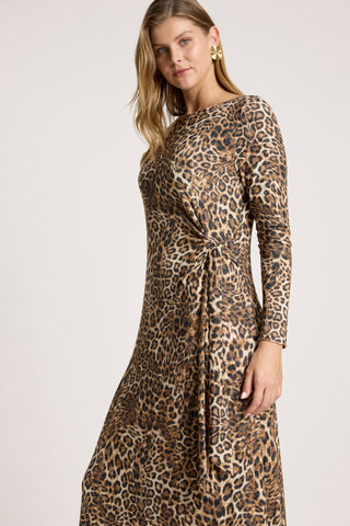 Woman wearing a long-sleeve leopard print maxi dress with a waist tie detail.