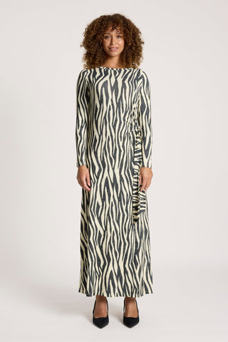 Woman wearing a long-sleeved zebra print maxi dress in black and cream.