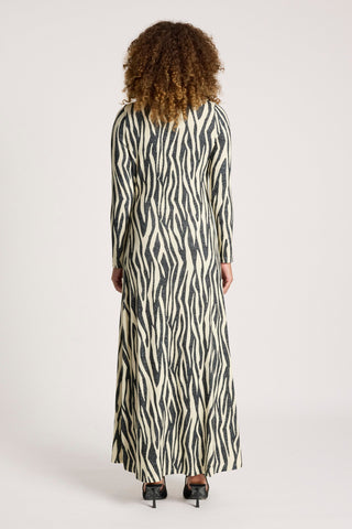 Woman in a long-sleeve maxi dress with a black and white zebra print pattern.