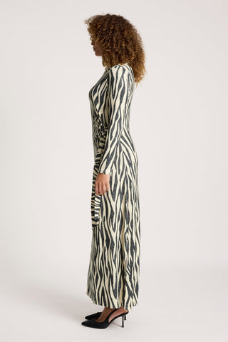 Woman in a long-sleeved zebra print maxi dress and black high heels.