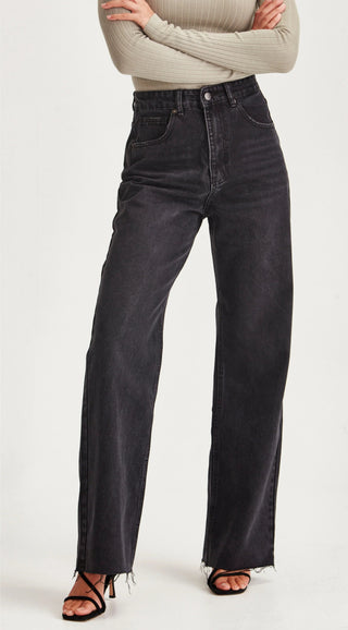 Woman wearing high-waisted black wide-leg denim jeans with raw hem.