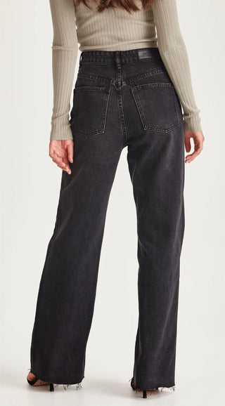 Woman wearing black wide leg denim jeans with frayed hem.