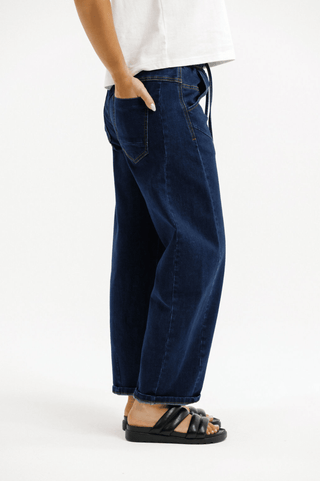Woman wearing dark wash wide leg denim jeans and black platform sandals.
