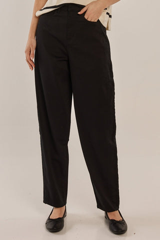Woman wearing black high-waisted wide leg trousers and black ballet flats.