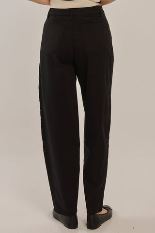 Woman wearing black high-waisted wide leg trousers and black flats.