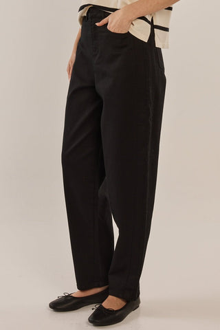Woman wearing black high-waisted wide leg trousers and black ballet flats.