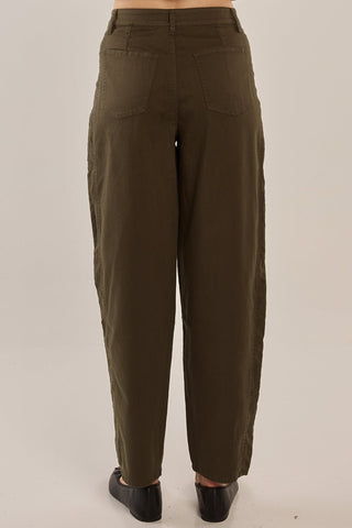 Woman wearing olive green wide leg lounge pants and black loafers.