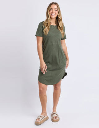 Woman wearing an olive green short sleeve casual t-shirt dress and beige platform sandals.