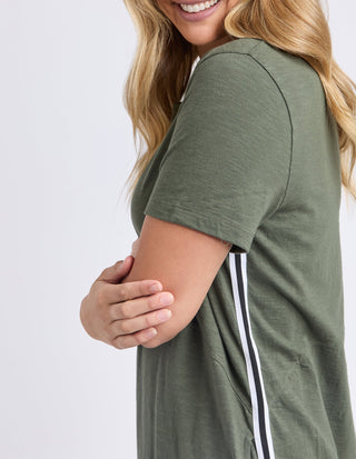 Woman wearing an olive green short sleeve t-shirt with white side stripes.