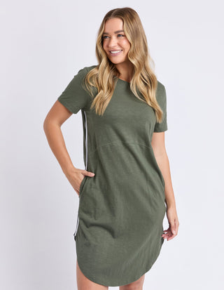 Woman smiling in an olive green short sleeve t-shirt dress with side stripe detail.