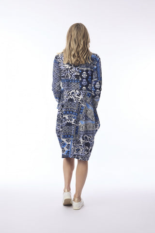 Woman in a blue and white patterned midi dress with long sleeves, back view.