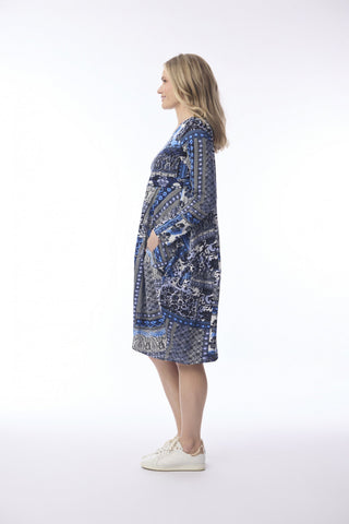 Woman in a blue patterned midi dress with long sleeves and side pockets
