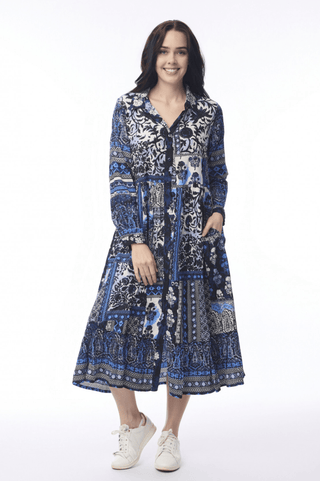 Woman wearing a blue patterned midi dress with long sleeves and pockets.