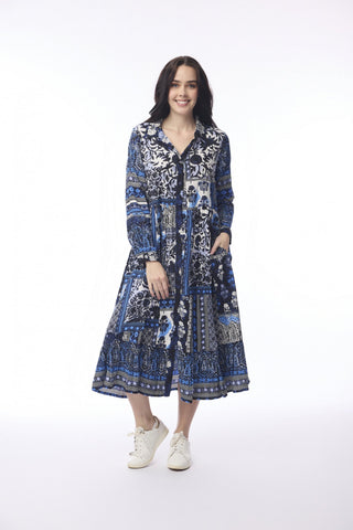 Woman wearing a blue and white patterned long sleeve maxi dress and white sneakers.