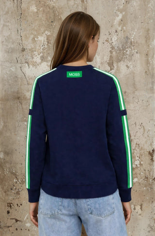 Rear view of a woman wearing a navy blue MOSS sweatshirt with green side stripes and light blue jeans