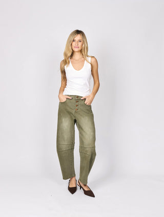 Woman wearing a white tank top and olive green cargo pants with brown heels.