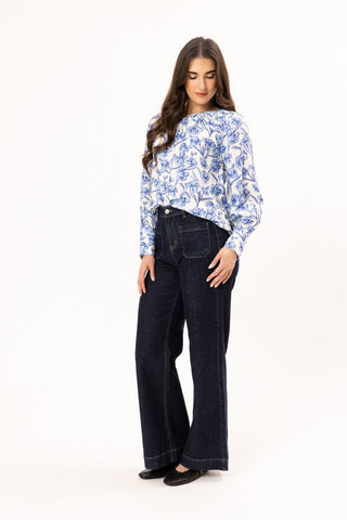 Woman wearing a blue and white floral print long sleeve top with dark wash wide leg jeans.