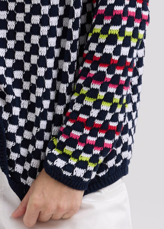 Close-up of a navy blue and white checkered knit cardigan with colorful neon accents