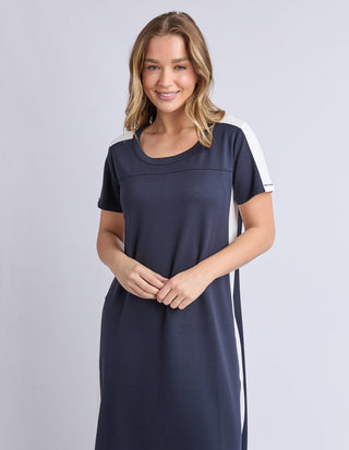 Woman wearing a navy blue and white striped short sleeve jersey maxi dress.