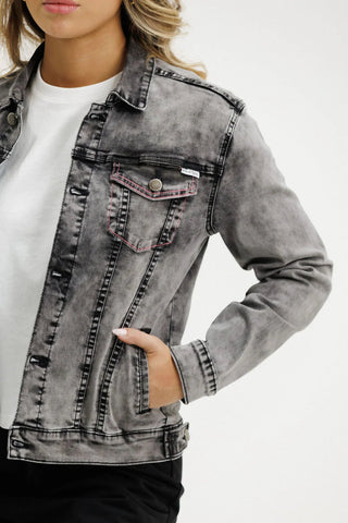 Woman wearing a grey washed denim jacket over a white t-shirt