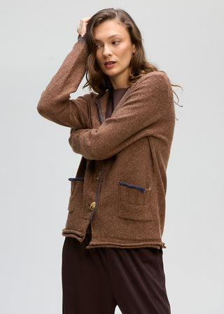 Woman wearing a brown textured knit cardigan with button closure and pockets.