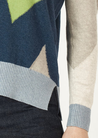 Close-up of a navy blue geometric patterned knit sweater with light blue ribbed trim.