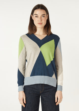 Woman wearing a geometric pattern V-neck knit sweater in blue, green, and beige tones.