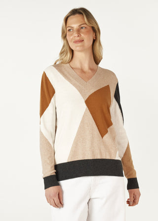Woman wearing a geometric pattern V-neck knit sweater in beige, brown, and black tones.