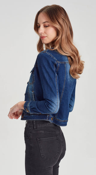 Woman wearing a blue denim jacket and black skinny jeans.