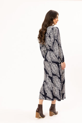 Woman wearing a navy blue and white patterned long sleeve maxi dress and brown ankle boots.