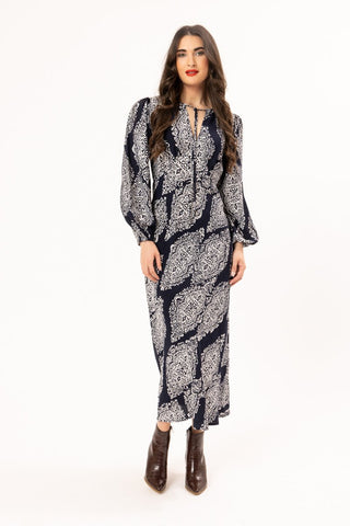 Woman wearing a long-sleeved navy blue and white patterned maxi dress with ankle boots.
