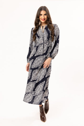 Woman wearing a navy and white patterned maxi dress with long sleeves and ankle boots.