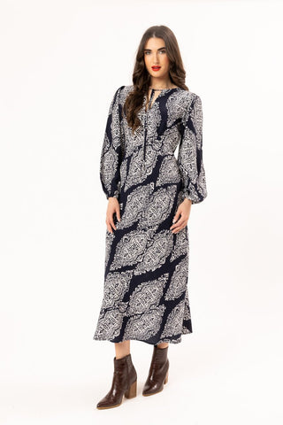 Woman wearing a navy blue and white patterned long sleeve maxi dress and brown ankle boots