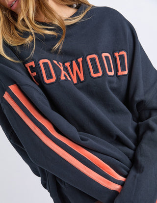 Foxwood navy blue sweatshirt with coral orange lettering and stripe details on sleeves.