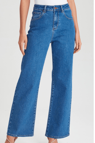 Woman wearing high-waisted blue denim wide-leg jeans.