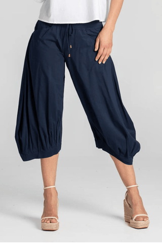 Woman wearing navy blue cropped wide-leg culottes and beige wedge sandals.