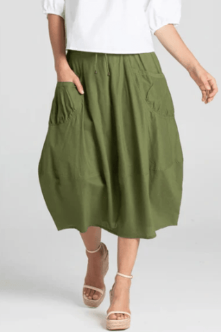 Woman wearing an olive green midi skirt with pockets and neutral wedge sandals