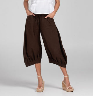 Woman wearing brown wide-leg cropped lounge pants and beige wedge sandals.