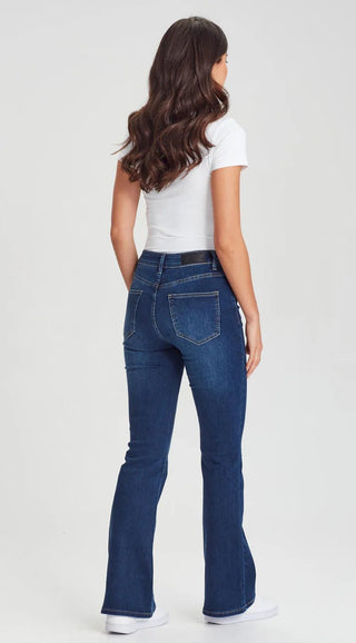 Woman wearing white t-shirt and dark blue flare denim jeans.