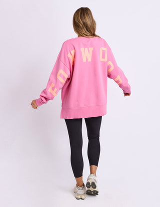 Woman wearing a pink Foxwood oversized sweatshirt and black leggings from behind.
