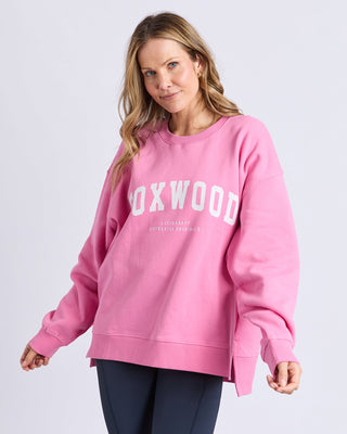 Woman wearing a pink Foxwood oversized sweatshirt and navy leggings