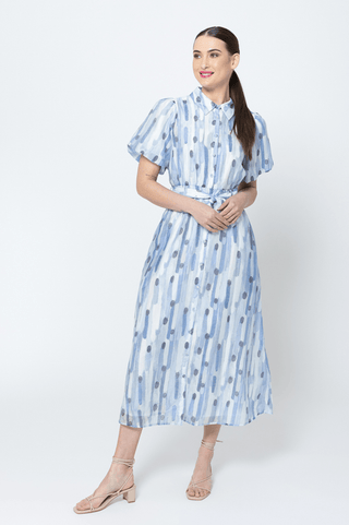 Woman wearing a blue and white abstract print midi dress with a tie waist and short sleeves