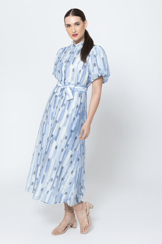 Woman wearing a blue and white abstract print midi dress with a tie waist and puff sleeves.
