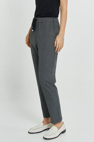 Woman wearing grey textured ankle-length pants and white loafers