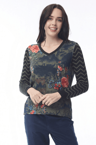 Woman wearing a floral print V-neck long sleeve sweater and navy pants.