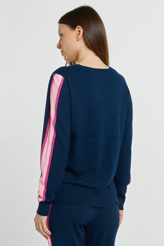 Woman wearing a navy blue sweatshirt with pink side stripes and matching leisure pants.