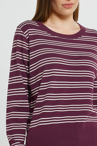 Woman wearing a maroon and white striped long sleeve sweatshirt.