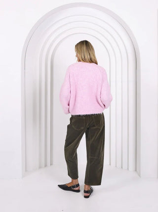 Woman from behind wearing a pink fuzzy sweater and olive green corduroy pants.